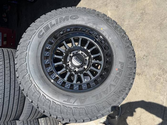 Black KMC wheel with a Prevail all-terrain tire